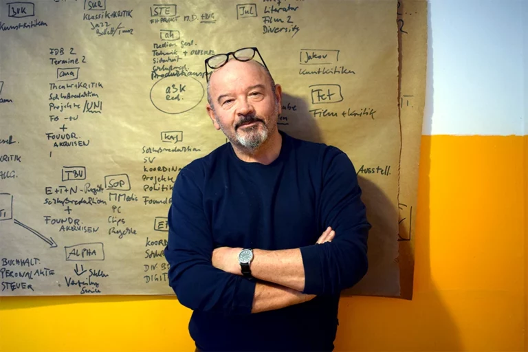 Jürgen Kannler mit verschränkten Armen vor einem Flipchart-Papier